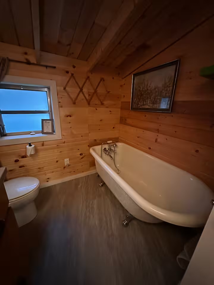 Wood-clad bathroom with a claw-foot soaker tub