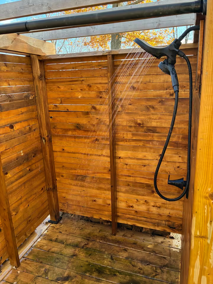 Private outdoor shower under autumn trees