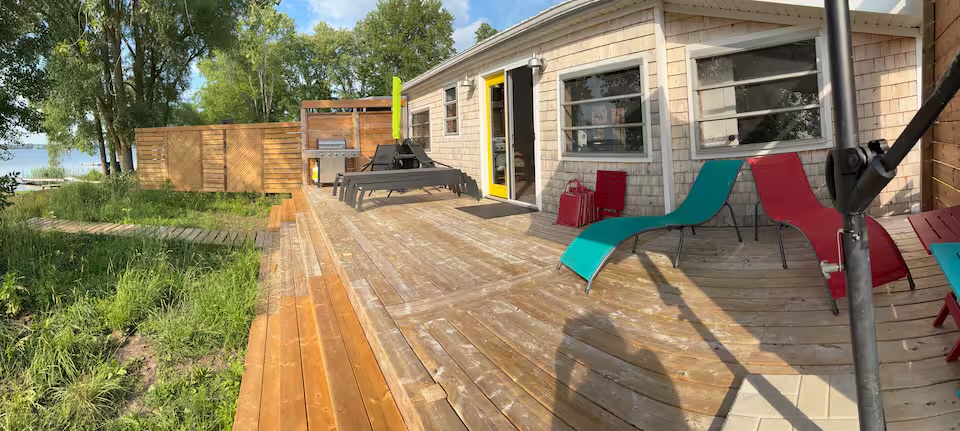 Large cottage deck with colourful lounge chairs