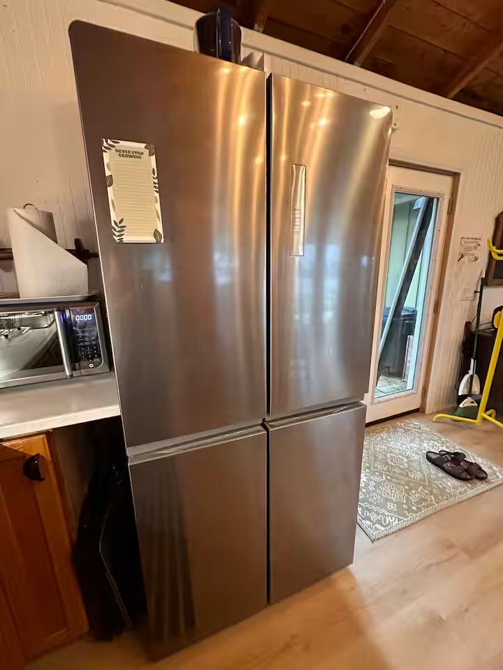Full-size stainless steel refrigerator in the cottage kitchen
