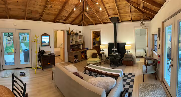 Living area, wood stove, and lake-facing doors